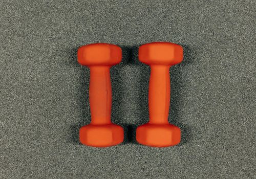 Minimalist workout equipment like dumbbells and a resistance band on the floor.